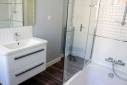 Salle de bain rénovée avec meuble vasque suspendu et combiné douche et baignoire - Rochefort 17