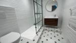 La salle de bain rénovée avec sa paroi de douche