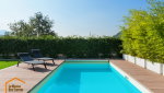 Piscine dans un jardin avec contour en bois