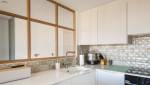 Cuisine moderne avec placards marron clair et plan de travail blanc
