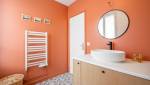 Murs de couleur rouge audacieuse dans une salle de bain moderne à Paris 8e