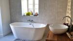 Baignoire ilot dans salle de bain en pierres