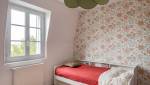 Lit simple et mur floral pour une chambre élégante à Paris 8e