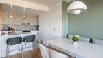 Banquette confortable et mur vert dans une cuisine rénovée