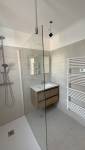 douche rénovée avec vitre et meuble vasque bois La Maison Des Travaux Ales