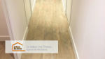 Gros plan sur le parquet du couloir, mettant en avant la texture et les nuances boisées du sol. 
