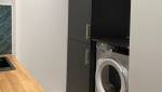 Face au plan de travail, le réfrégirateur et machine à laver le linge