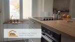 Vue de la nouvelle cuisine avec un magnifique plan de travail en bois clair, créant une ambiance chaleureuse et moderne.