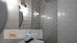 Zoom sur la douche à l’italienne, dotée d’un receveur plat et d’une paroi en verre, pour une esthétique minimaliste et fonctionnelle.