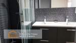 Vue de la douche moderne avec paroi en verre à rayures et robinetterie haut de gamme, pour un espace à la fois fonctionnel et esthétique.