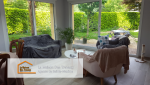 Espace salon de l’extension, aménagé confortablement, permettant de profiter d’une ambiance cosy tout en restant ouvert sur la nature environnante.