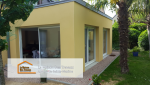 Vue intérieure de l'extension avec de grandes baies vitrées, baignant l’espace de lumière naturelle et offrant une vue apaisante sur le jardin.