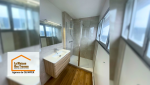 Photo 3 : Vue complète de la salle de bain rénovée à Bénodet, mêlant bois, carrelage moderne et douche spacieuse.