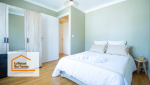 Chambre principale moderne et reposante : Une chambre lumineuse avec des teintes vertes et un mobilier élégant pour une ambiance zen.
