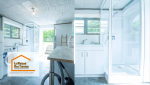 Détail de cuisine moderne : Des accessoires pratiques et décoratifs installés sur un plan de travail en bois clair, soulignant le design soigné de la cuisine.