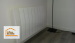 Un radiateur moderne soigneusement installé, s’intégrant parfaitement dans un intérieur rénové avec des finitions épurées.