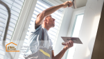 Un artisan en plein travail sur un mur, appliquant un enduit avec précision pour lisser les imperfections. 
