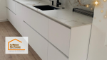 La cuisine toute en modernité avec un plan de travail en marbre veiné et un évier noir mat, alliant design et praticité.