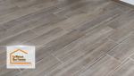 Gros plan sur le carrelage imitation bois qui donne une ambiance moderne et naturelle à la pièce. La finition impeccable reflète le travail minutieux des artisans locaux