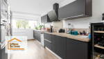 Rénovation de cuisine à Layrac : Transformation moderne avec meubles noirs et plan de travail en bois. Une cuisine élégante et fonctionnelle.