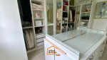 Dressing sur mesure avec îlot central vitré, rangements ouverts et penderies intégrées – aménagement intérieur en Haute-Savoie.