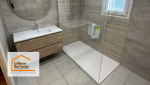 Salle de bain rénovée avec espace rangement : Associez style et fonctionnalité avec un meuble vasque moderne et un dressing intégré pour un agencement optimisé.