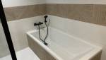 Une baignoire habillée avec de la faïence imitation bois