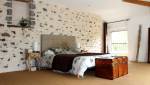 Aménagement d’une chambre sous combles mur en pierre