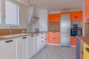 Cuisine multicolore dans un appartement de Lyon quai de Saône : vue sur le linéaire côté fenêtre et les armoires de rangement