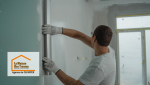 Finition des murs à Treffiagat – Un artisan applique les dernières touches sur des cloisons isolées, garantissant une finition impeccable.
