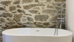 Mise en place de la baignoire à l'étage du loft accolée à la pierre de taille traitée sur Pleyben (29190)