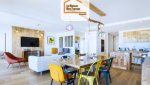 Pièce à vivre moderne en Haute-Savoie avec cuisine en bois clair, salle à manger colorée et salon ouvert – rénovation intérieure signée La Maison Des Travaux.