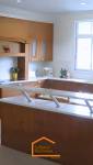 Cuisine en U avec meubles en bois massif et plan de travail blanc - rénovation à Bonneville (Haute-Savoie)