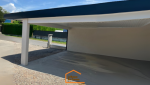 Carport double en Haute-Savoie avec toiture plate et espace de stationnement bétonné – réalisation contemporaine signée La Maison Des Travaux.