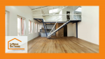 Aménagement d’un ancien dépôt en loft moderne et lumineux à Villeneuve-sur-Lot, avec parquet et mezzanine design. 