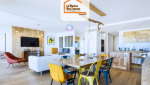 Pièce à vivre moderne en Haute-Savoie avec cuisine en bois clair, salle à manger colorée et salon ouvert – rénovation intérieure signée La Maison Des Travaux.
