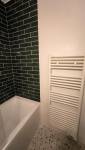 avoriaz-74110-renovation-appartement-salle-de-bain-baignoire-faience-noire-seche-serviettes