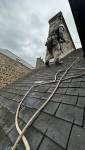 Intervention en toiture avec mise en sécurité par cordage, réalisée par un couvreur spécialisé dans les travaux en hauteur afin d’accéder à la zone d’infiltration.
