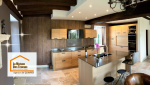 Rénovation complète d’une cuisine avec îlot central, éclairage encastré et finitions bois contemporain.