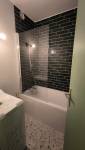 avoriaz-74110-renovation-appartement-salle-de-bain-baignoire-lave-linge-faience-noire