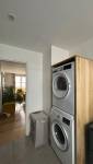 Espace buanderie avec lave-linge et sèche-linge dans une salle de bain moderne aux Batignolles