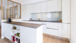 Aménagement cuisine ouverte avec délimitation verrière encadrement bois dans studio à Poincy (77470)