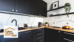 Cuisine contemporaine noire et bois rénovée près de Pont-l’Abbé, alliant design épuré, rangements fonctionnels et choix de matériaux durables pour un usage quotidien confortable.