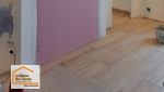 Pose de revêtement de sol effet bois à Fumel : préparation du support et ajustement précis pour un rendu esthétique et durable.