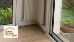 Finitions précises autour des murs et radiateurs après pose du nouveau sol, incluant une sous-couche pour améliorer confort et longévité du revêtement.