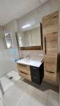 Intégration d'un receveur extra plat XXL dans salle de bain rénovée e nappartement avec meuble vasque adjacent