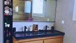 Meuble double vasque bois et plan noir mat dans une ambiance industrielle chic.