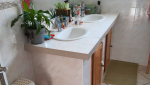 Salle de bain avant travaux avec baignoire et carrelage beige d’origine.