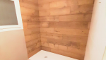 Espace douche avec carrelage imitation bois au veinage travaillé.