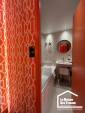 Pose d'un papier peint à motifs géométriques orange et blanc pour une chambre moderne.